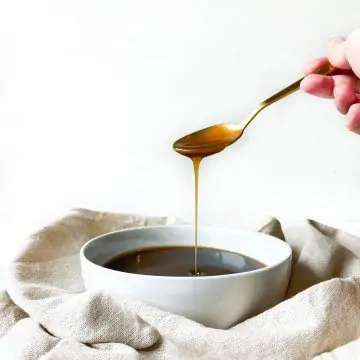 spoon drizzling caramel into a bowel of caramel.