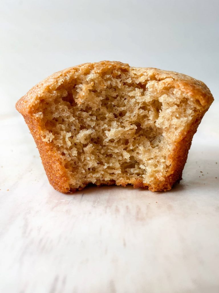 A single muffin with a bite taken out of it. 