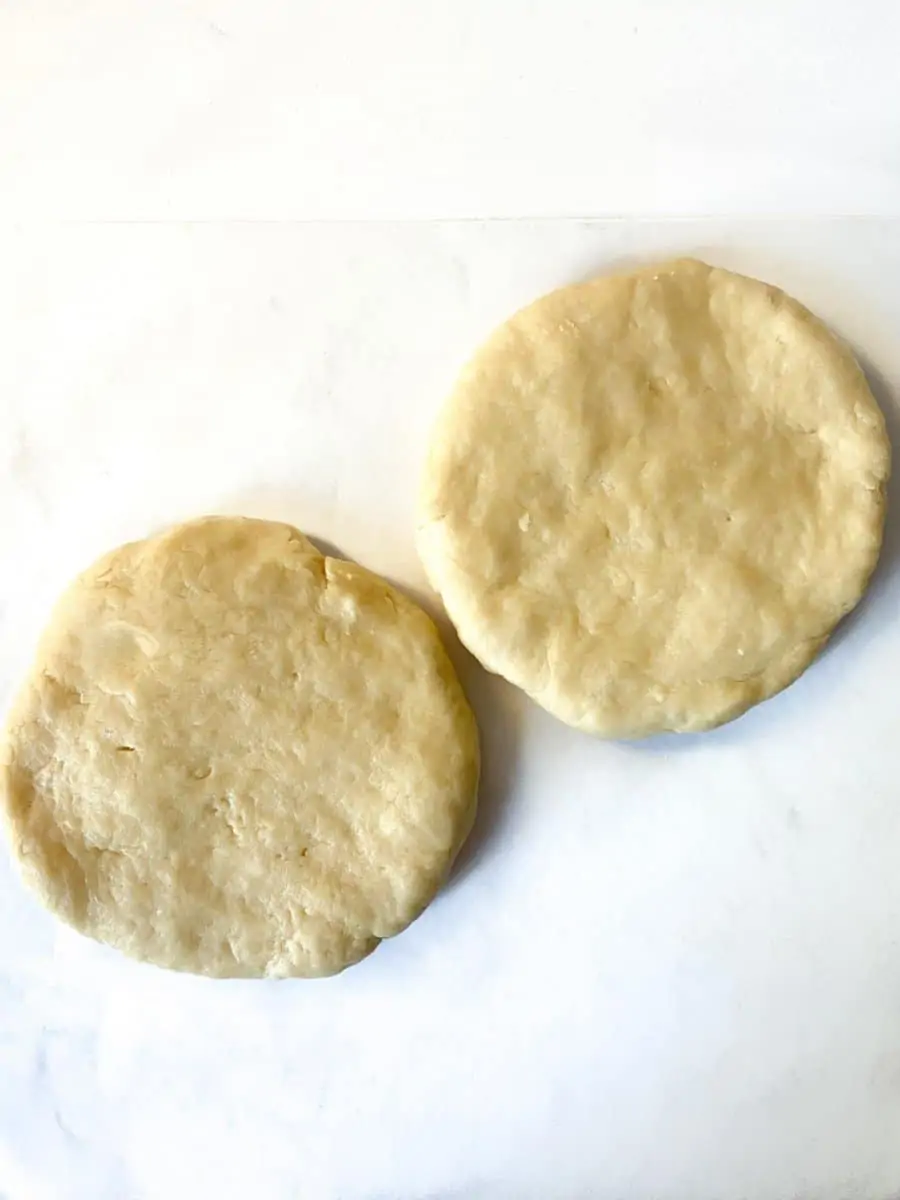 Two formed round disks of pie dough.