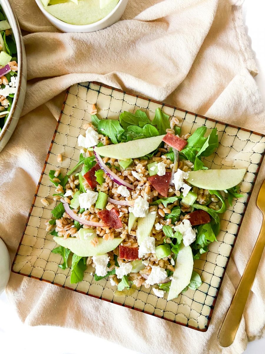 Garnished apple farro and bacon Salad on a plate. 