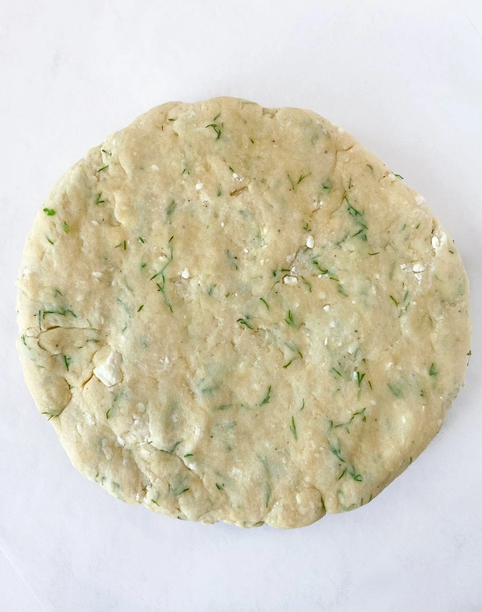 A disk of unbaked dill scone dough. 