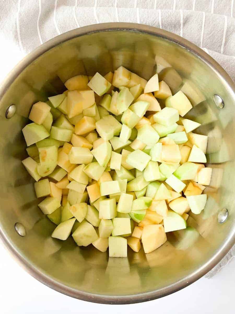 A nonstick pot filled with chopped apples.