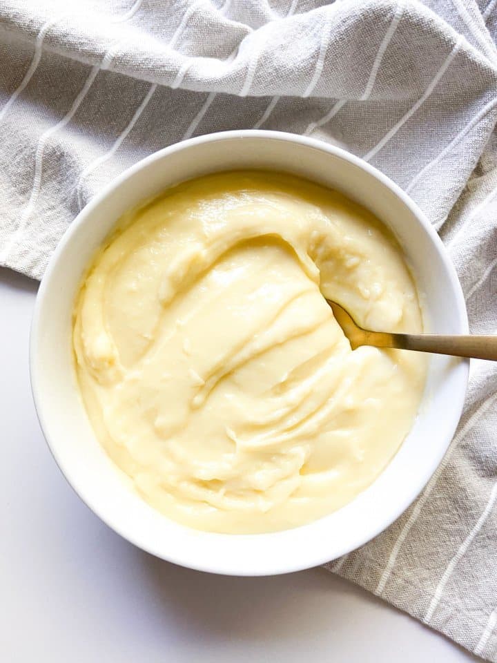 A bowl of pastry cream with a spoon.