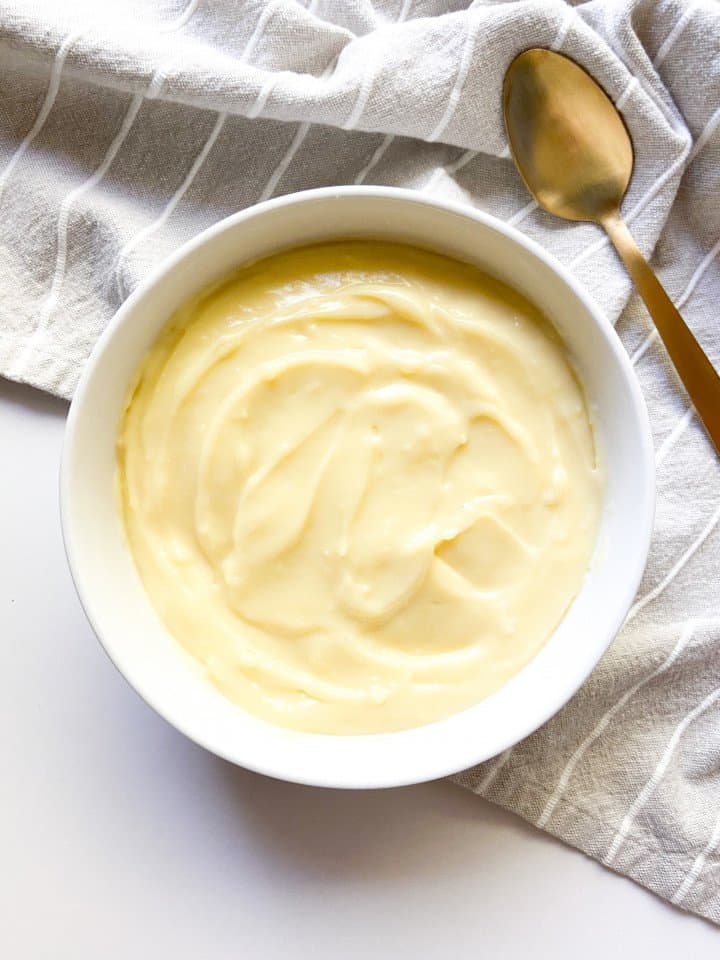 A bowl of pastry cream with a spoon.