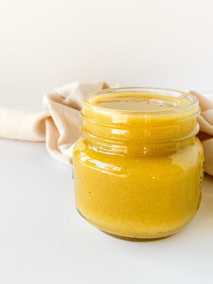 A mason jar full of completes salad dressing.