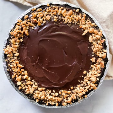 A whole garnished and completed ganache covered peanut butter pie.