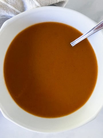 Espagnole sauce in a white bowl with a spoon.