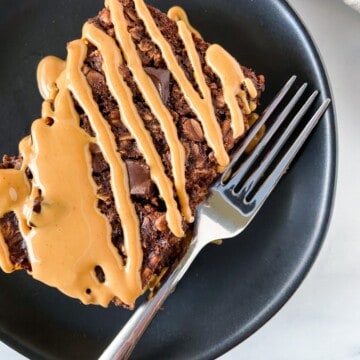 A slice of chocolate peanut butter baked oatmeal drizzled with peanut butter.
