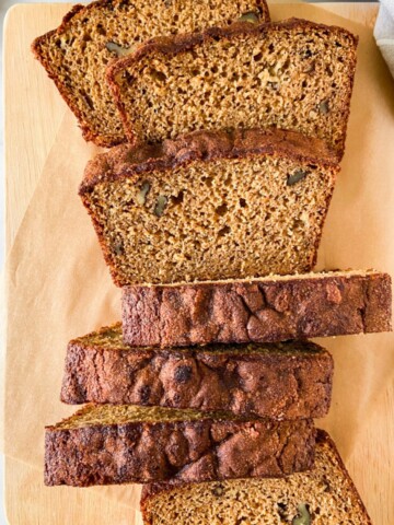 Banana bread slices on a parchment-lined cutting board.