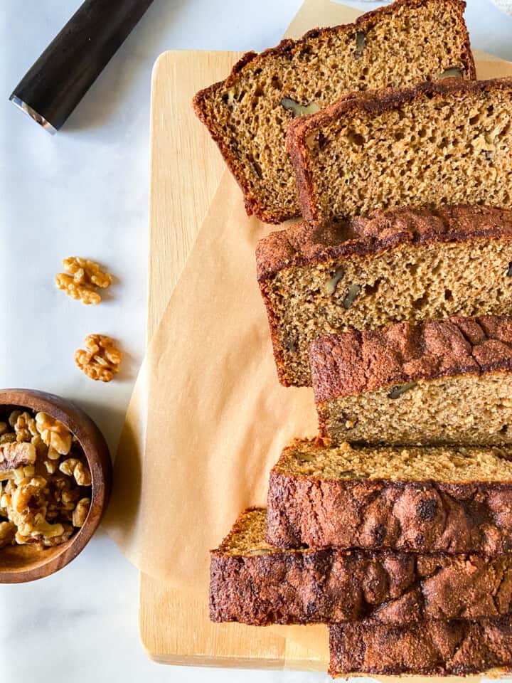 Banana bread slices on a parchment-lined cutting board.