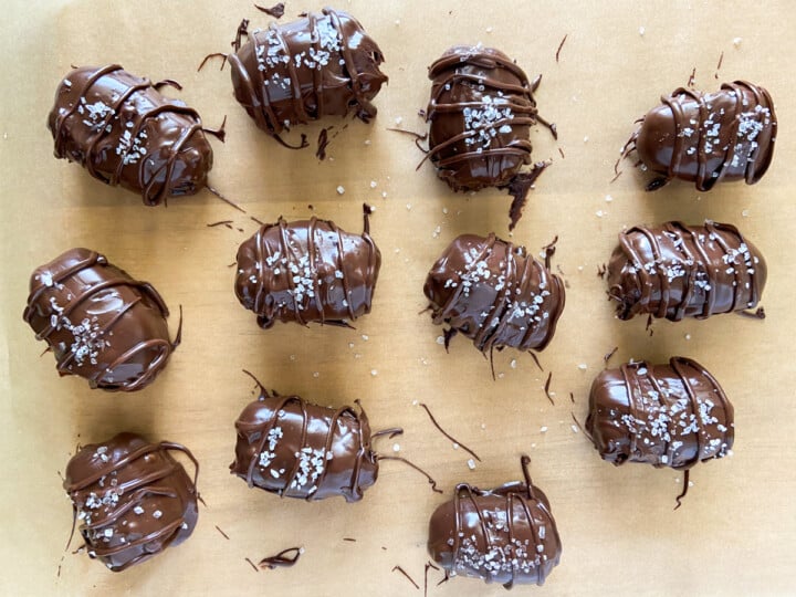 Chocolate coated dates on parchment paper.