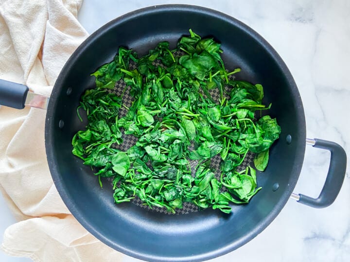 Sautéed spinach in a large skillet.