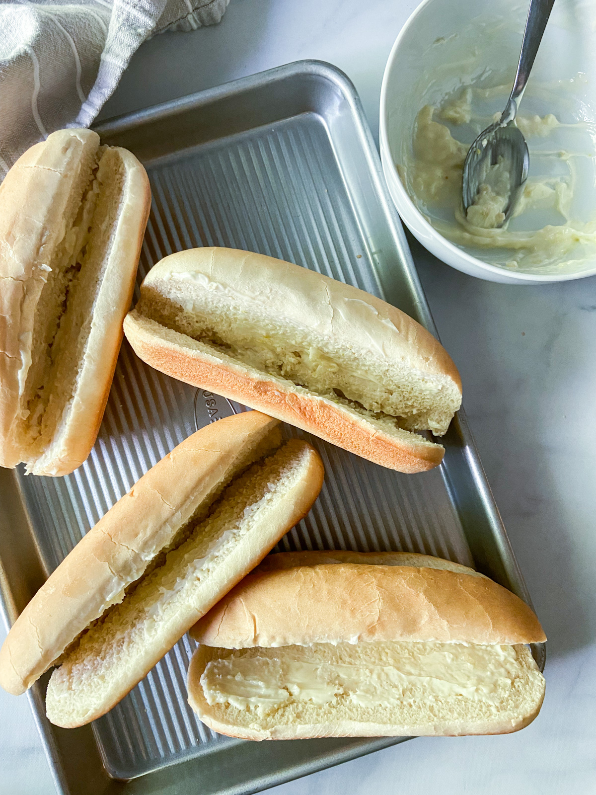 Four rolls with garlic butter spread inside.