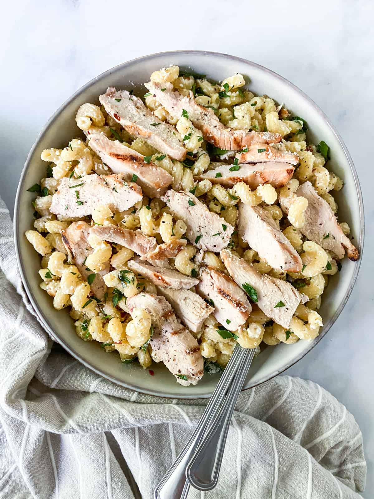 A bowl of chicken feta pasta with two forks.