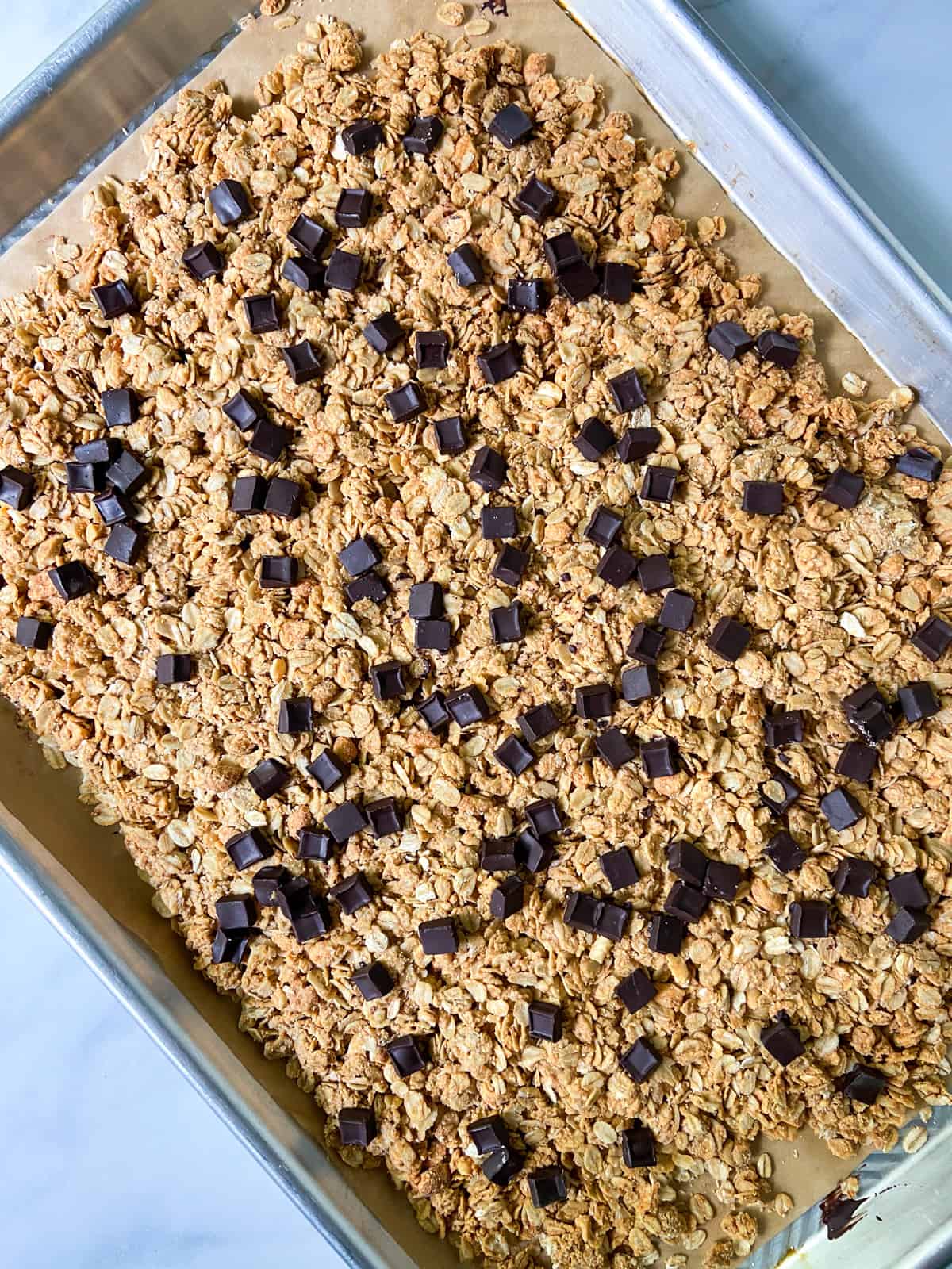 Baked granola with chocolate chunks on top.