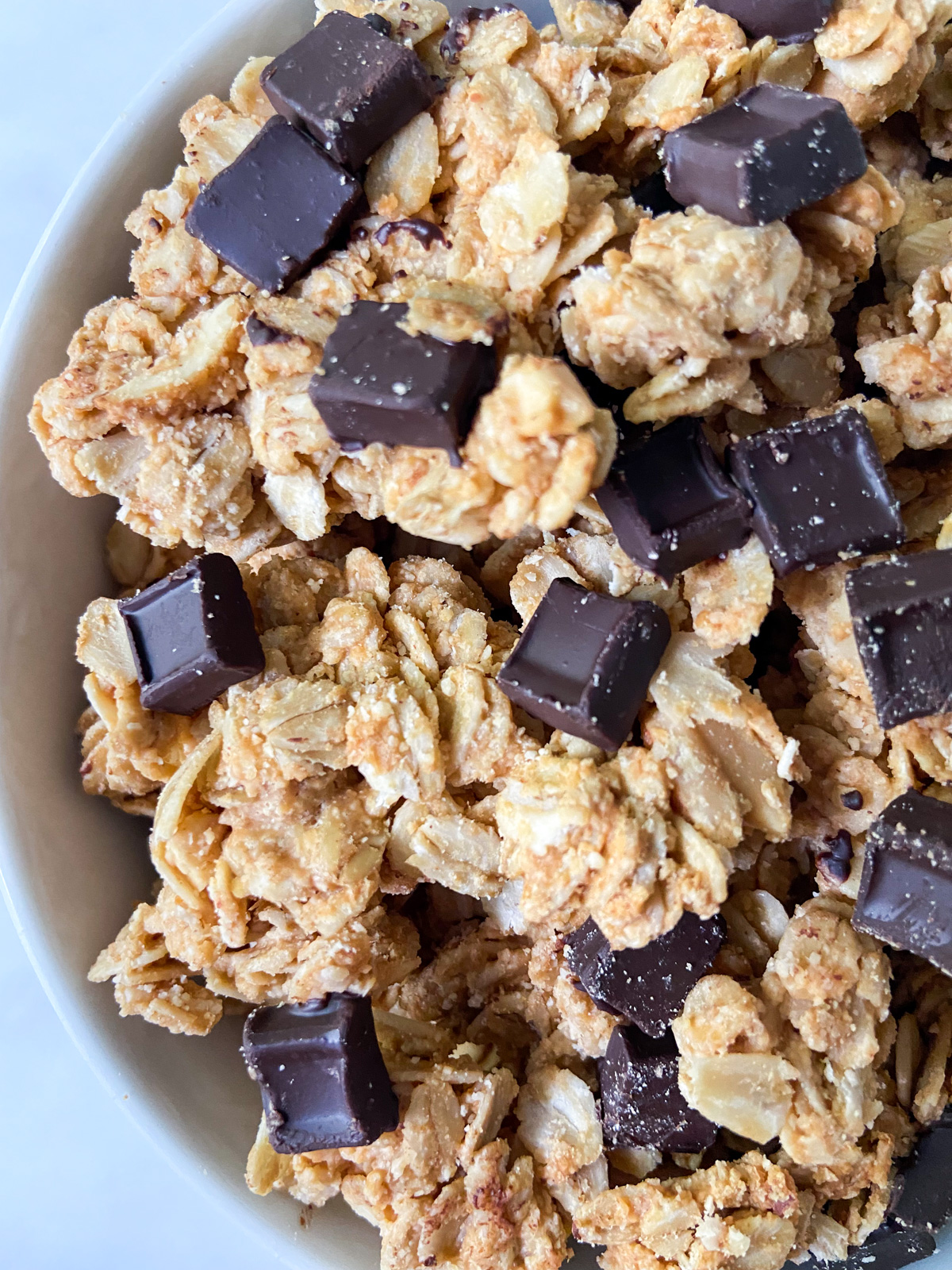 Granola clusters with chocolate chunks in a bowl.