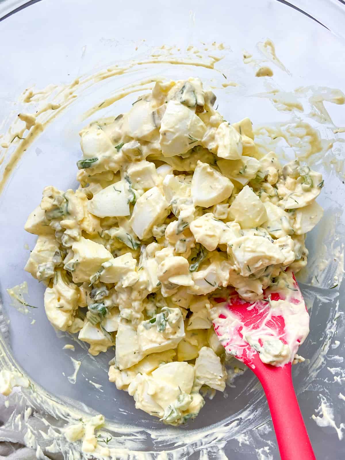 Completed egg salad in a large bowl with a spatula.