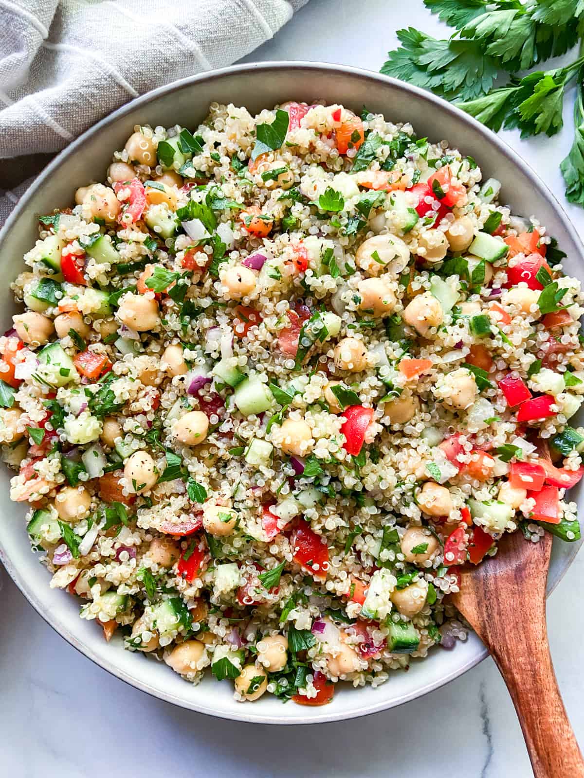 Quinoa salad with chickpeas in a large bowl with a wooden server.