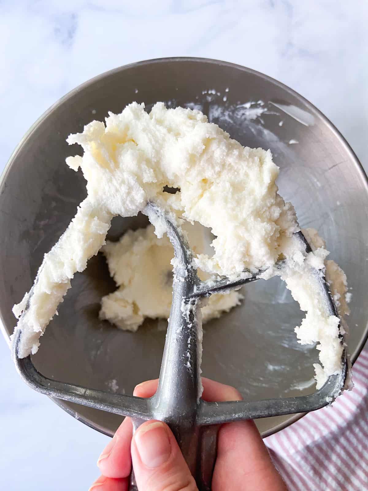 Whipped butter and sugar on a mixer paddle.