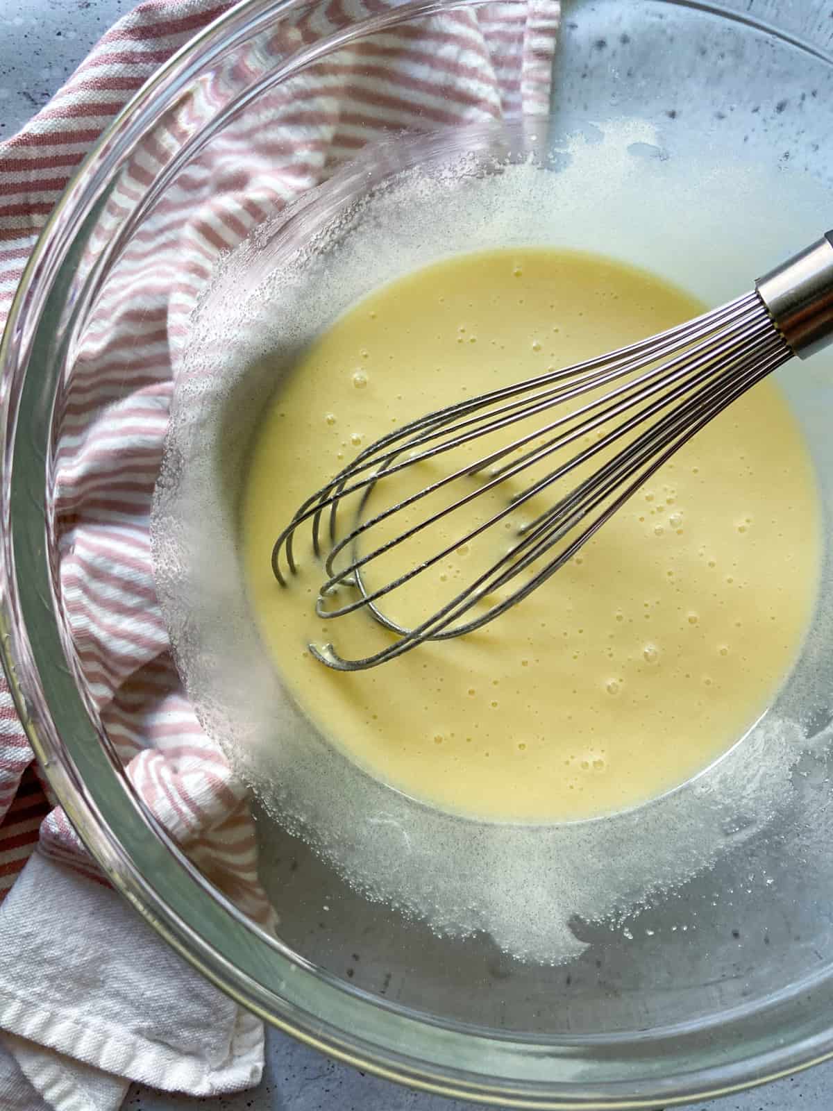 The completed egg-butter mixture in a bowl with a whisk.