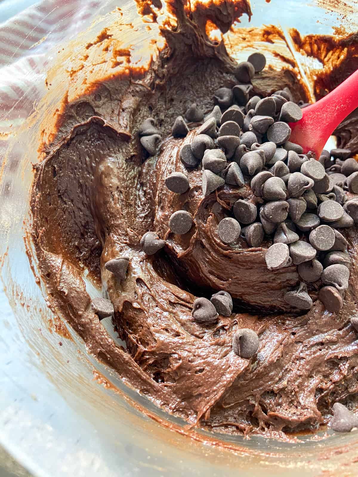 A bowl of brownie batter with chocolate chips added.