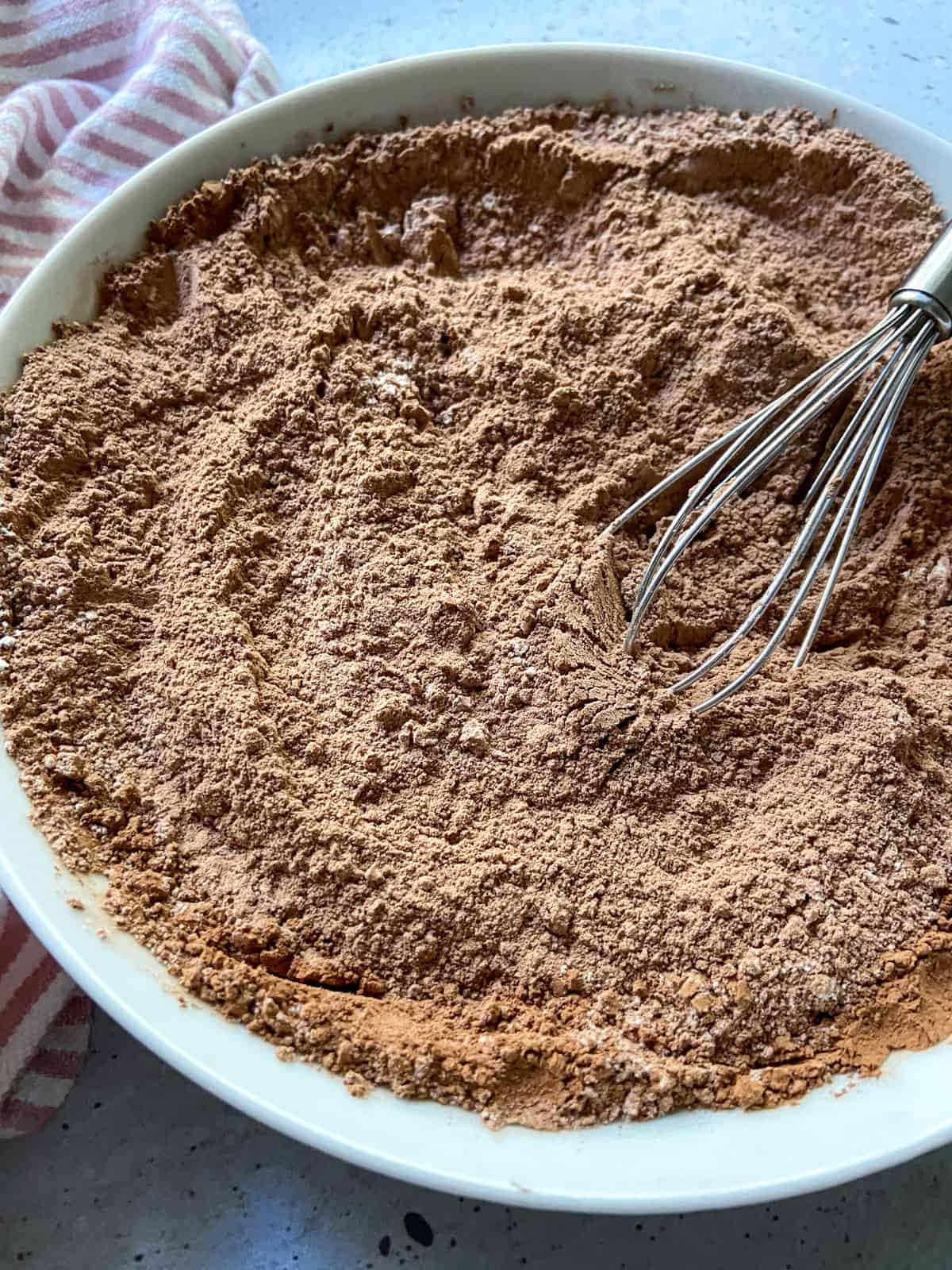 Flour, cocoa powder, and salt mixed together in a bowl with a whisk.