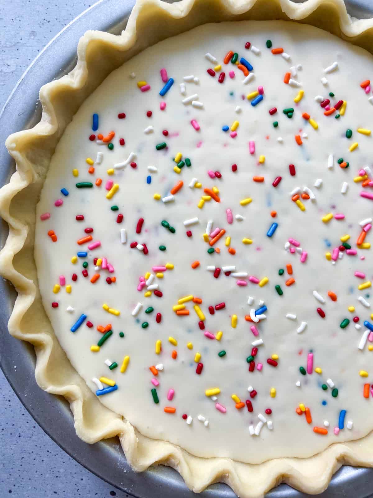 Funfetti cream cheese filling in an unbaked pie crust.