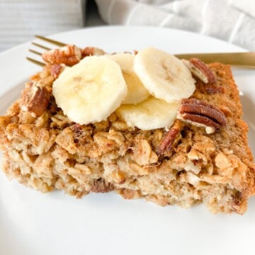 A slice of banana baked oatmeal topped with banana slices.