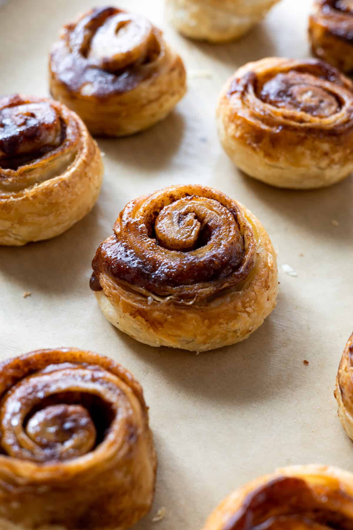 An array of unfrosted puff pastry cinnamon rolls.
