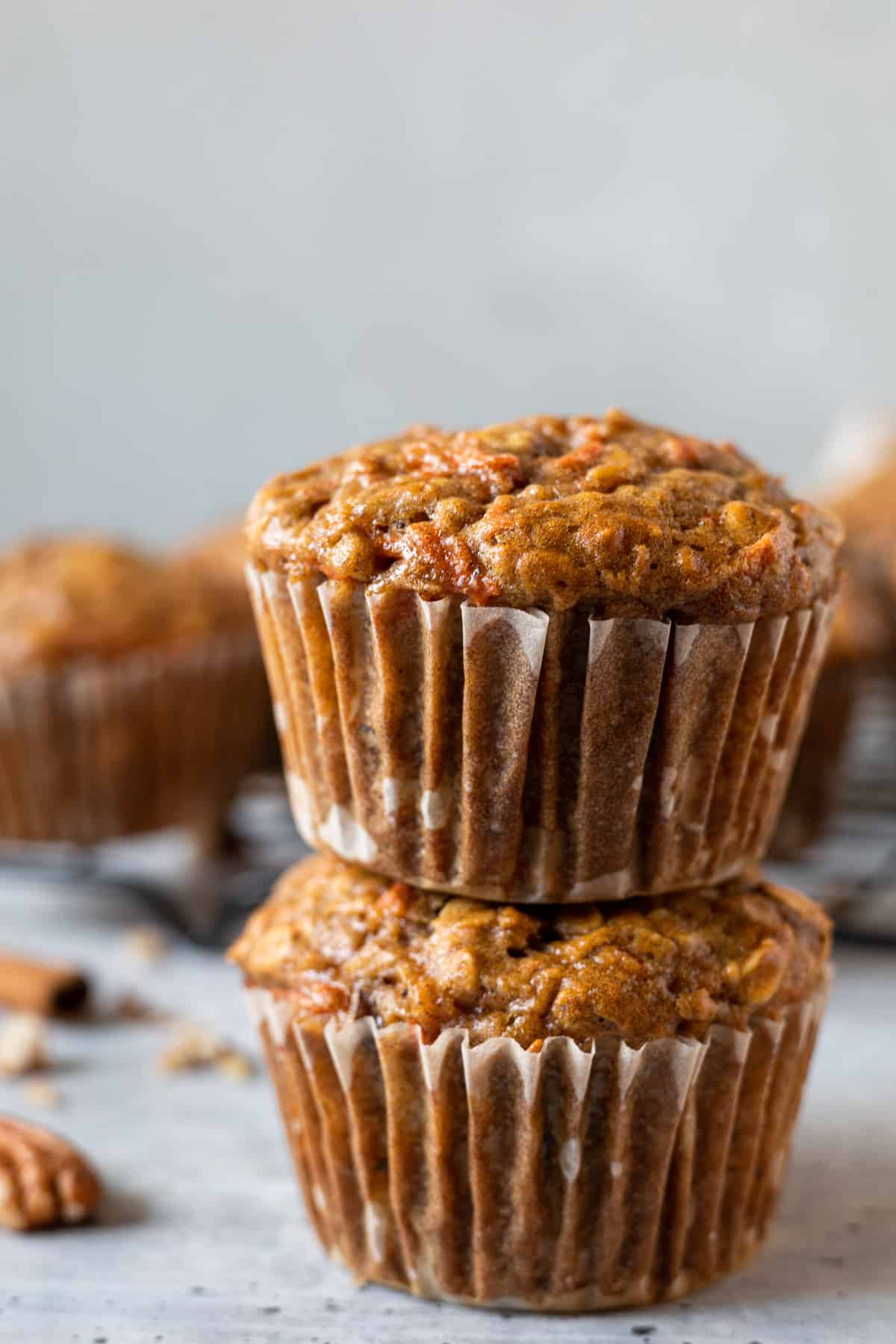 Two carrot apple muffins stacked on top of each other.