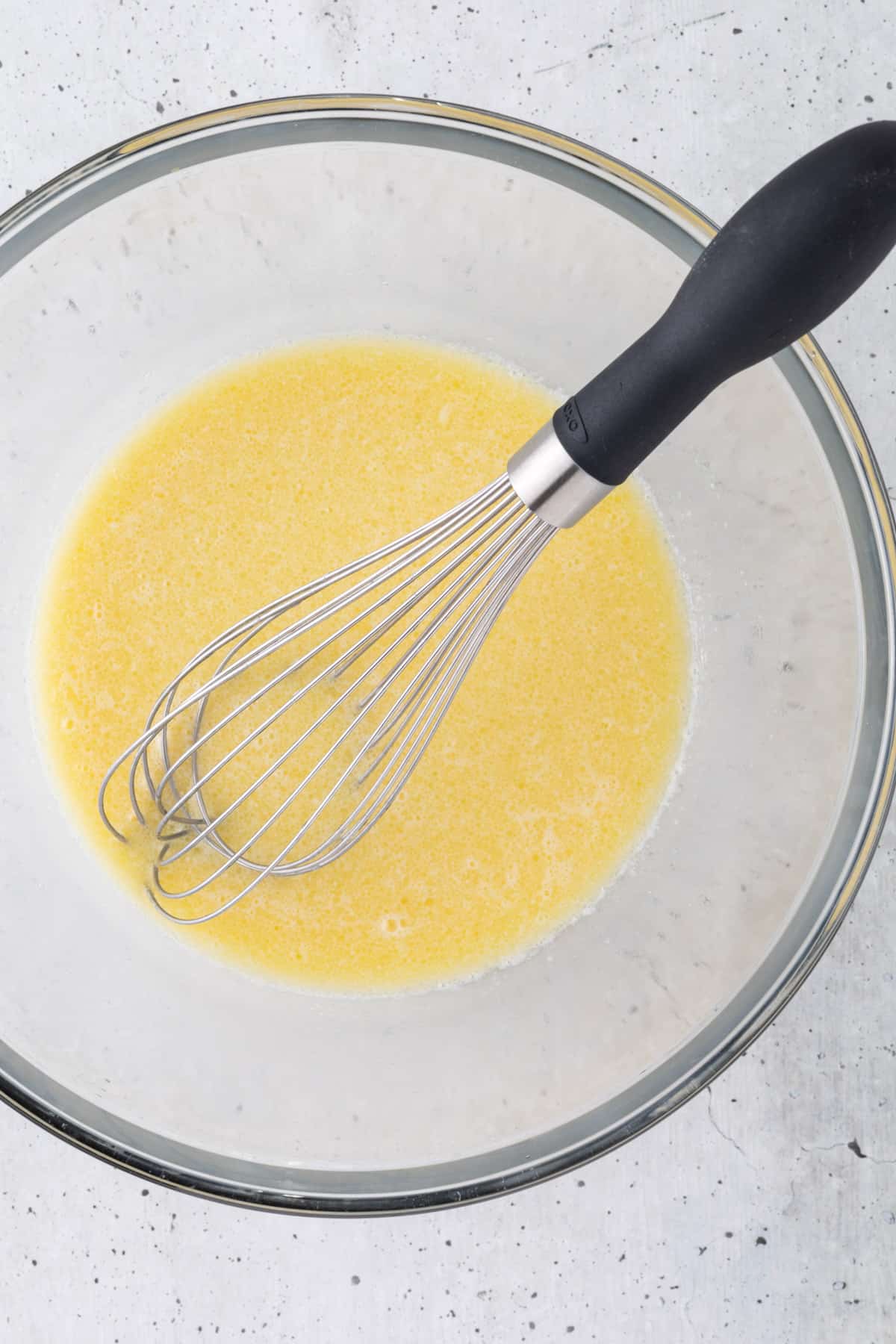The liquid ingredients in a large bowl with a large whisk.