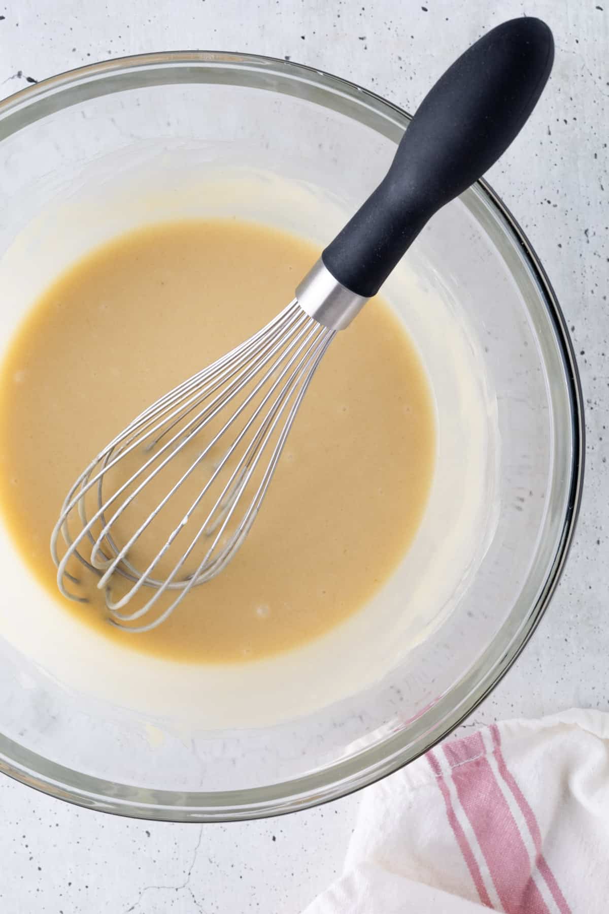 The wet ingredients in a large bowl with a whisk.