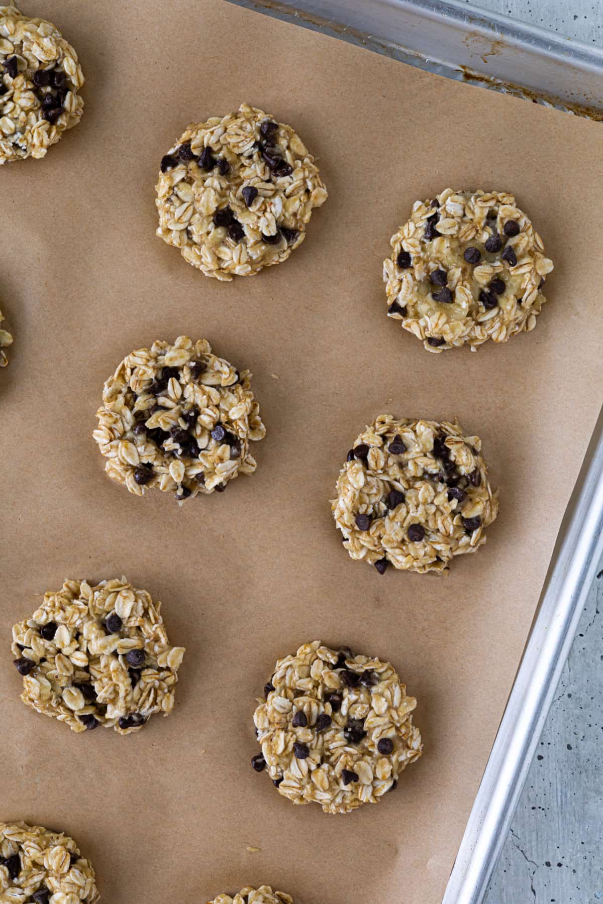 A parchment-lined tray with unbaked cookies.