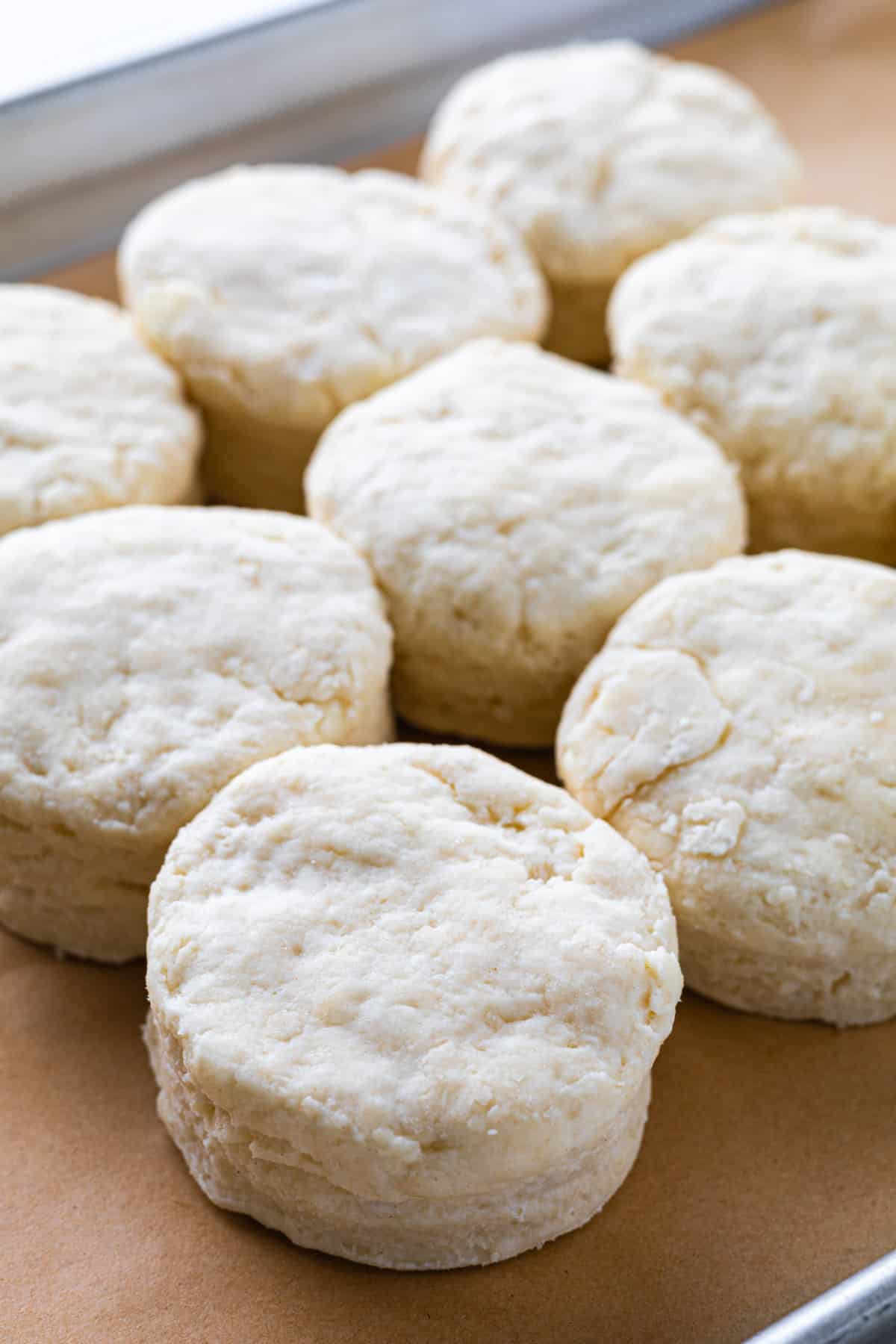Unbaked biscuits on a parchment-lined tray.