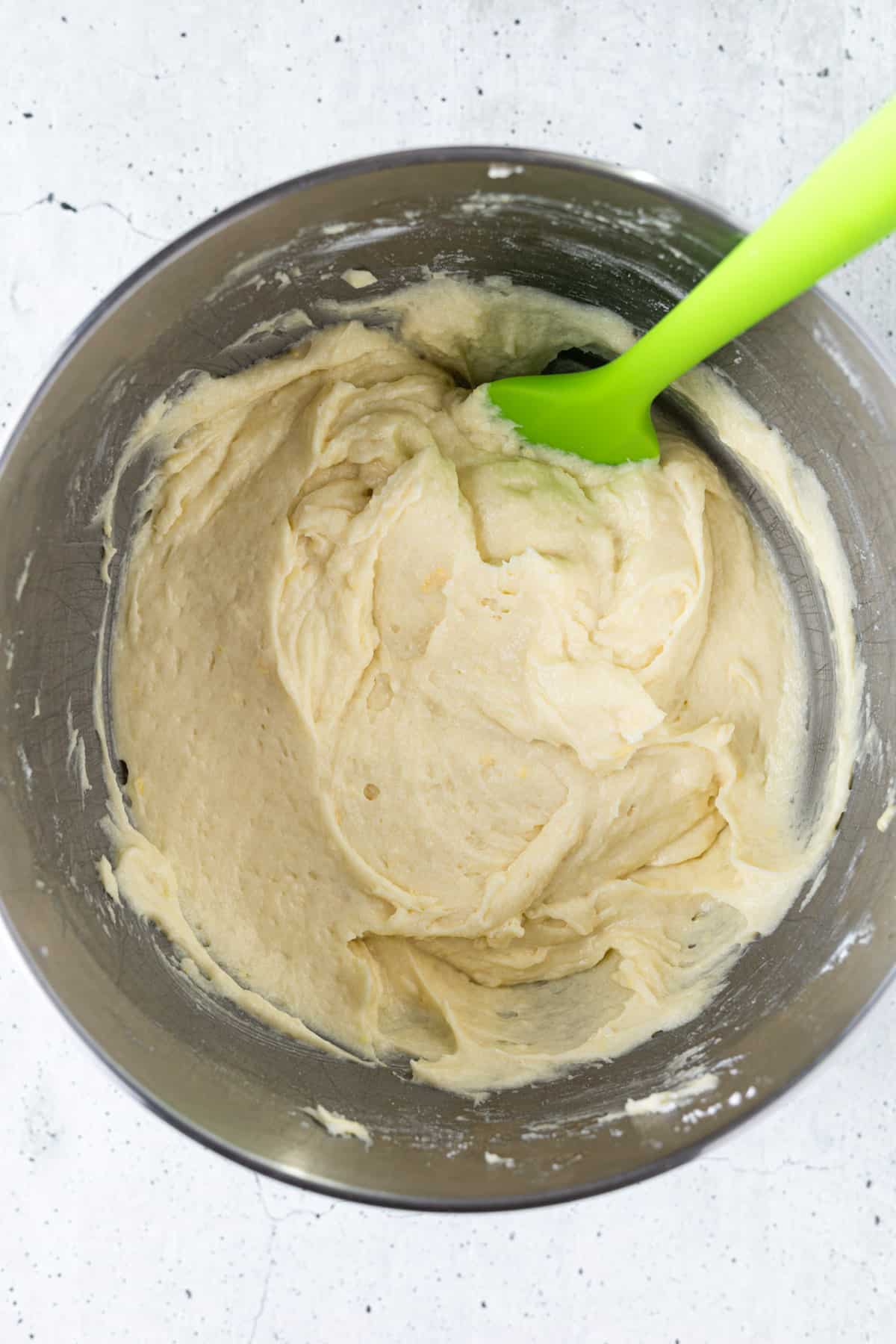 A bowl of cake batter with a rubber spatula.