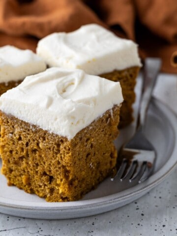 Three slices of pumpkin cake on a plate with a fork.