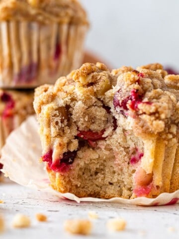 A cranberry walnut muffin with a bite taken out of it.
