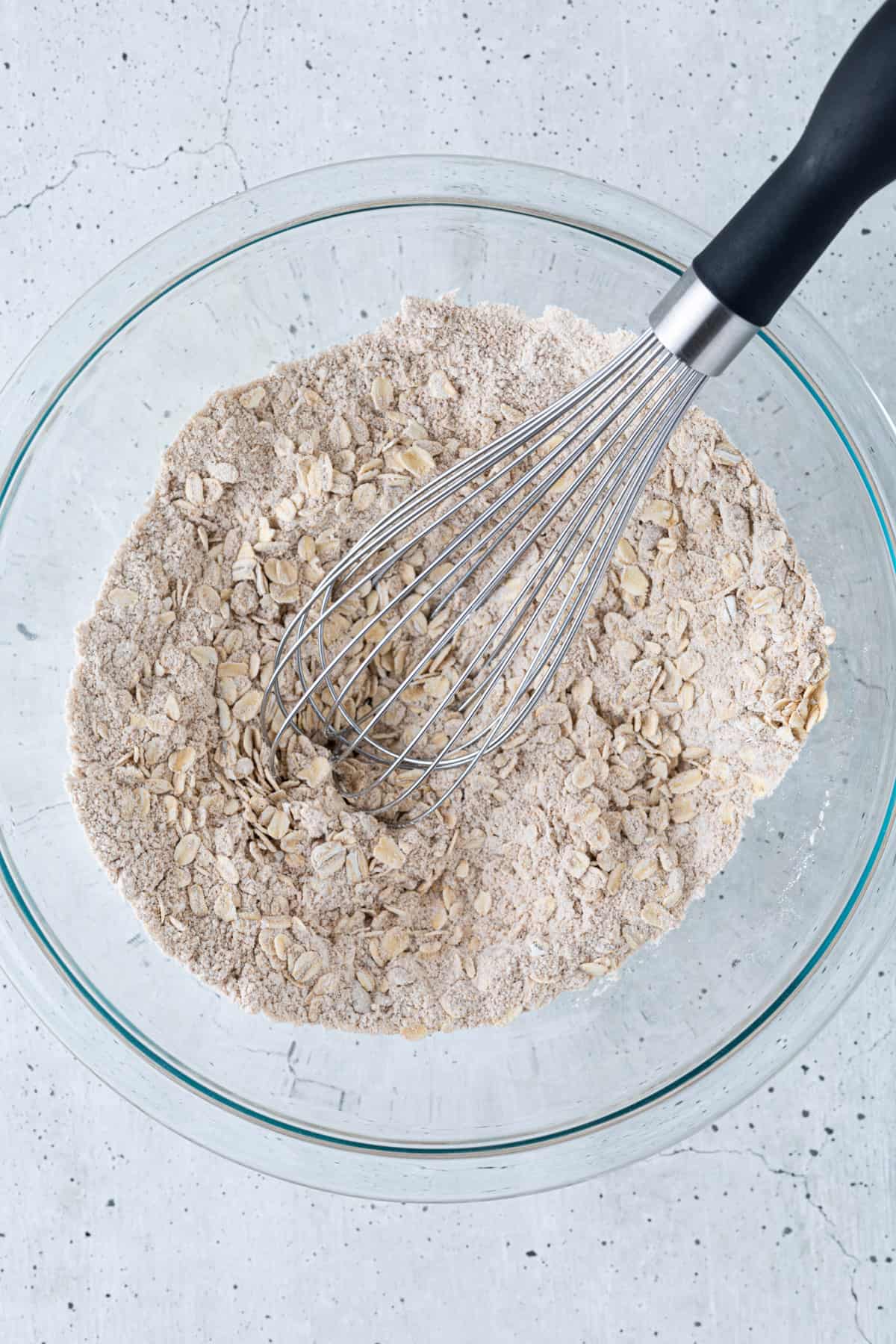 The dry ingredients in a bowl with a whisk.