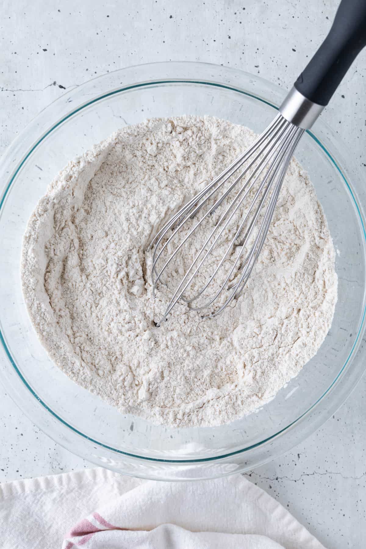 The dry ingredients in a large bowl with a large whisk.