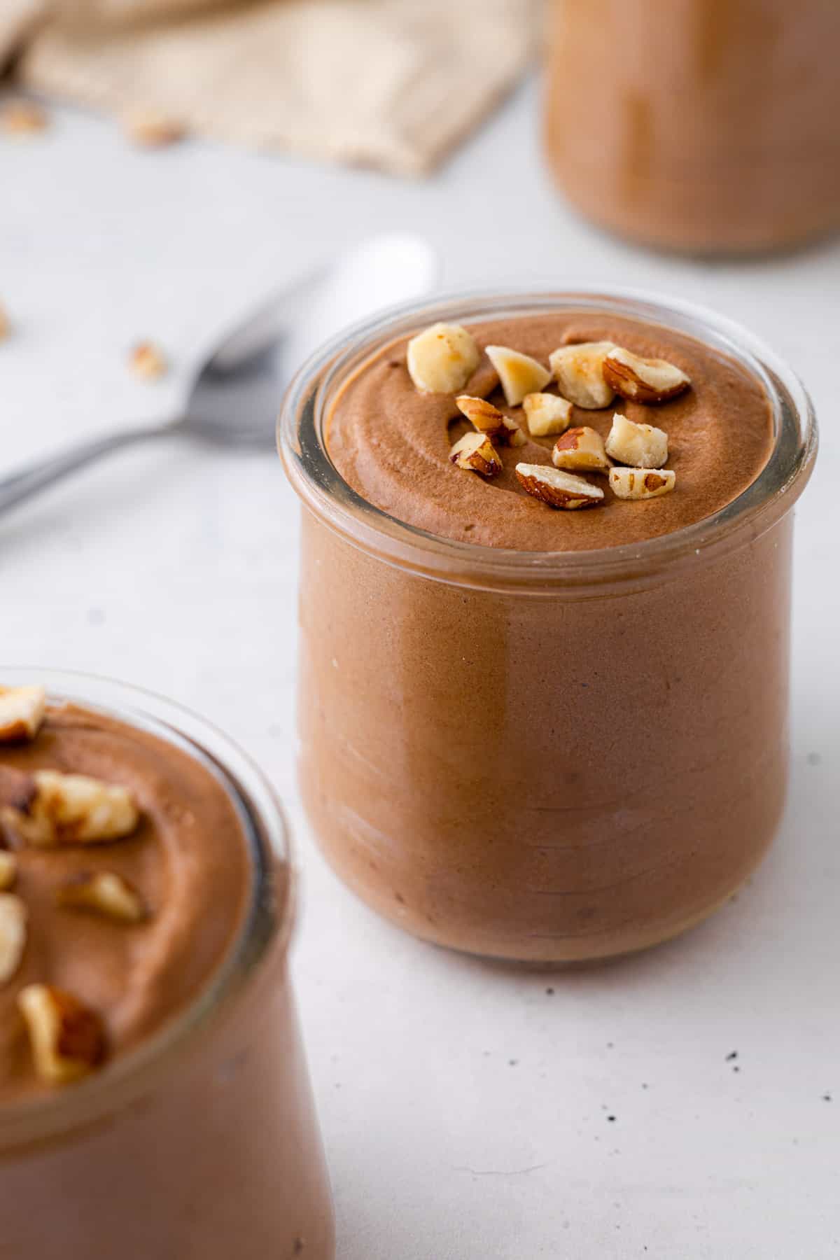 A jar of mousse with hazelnuts.