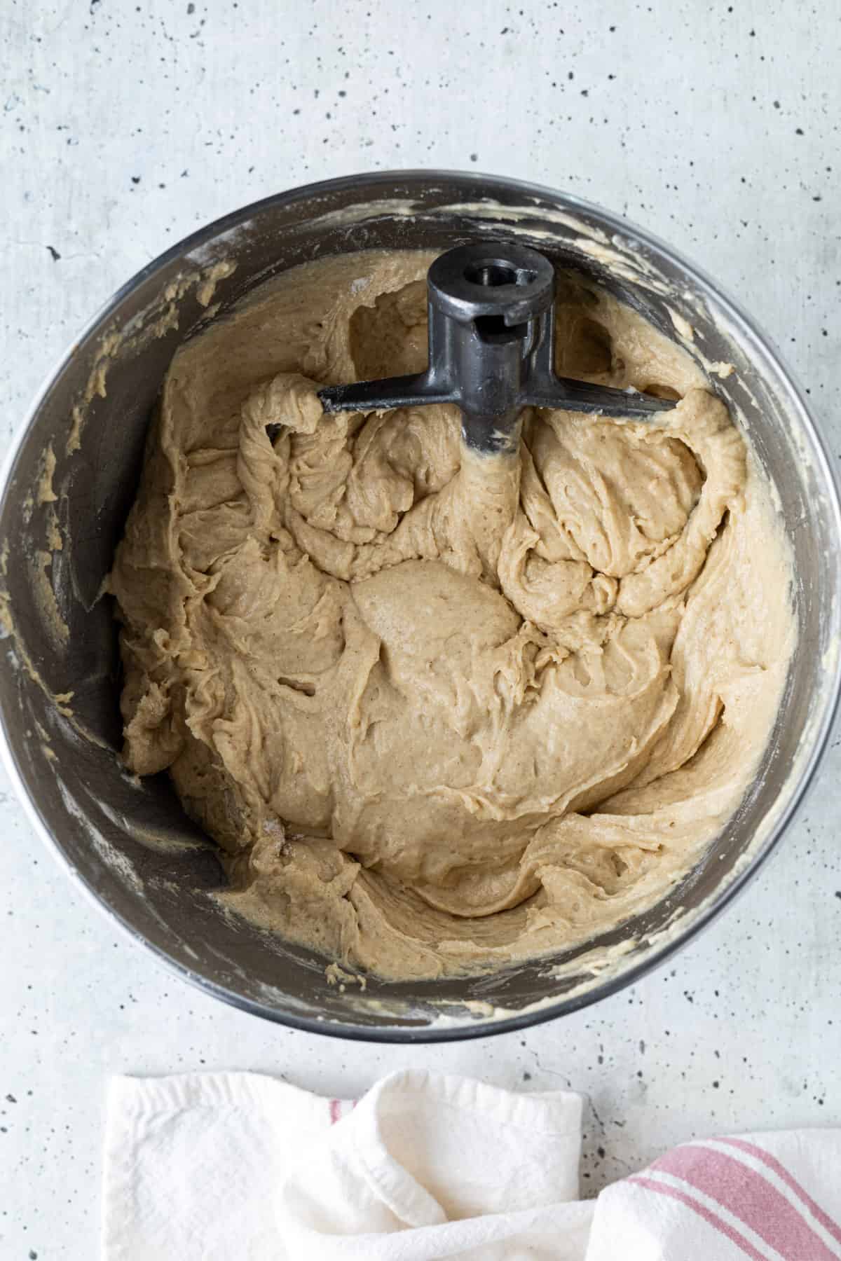 Cake batter in a mixer bowl with the paddle attachment.