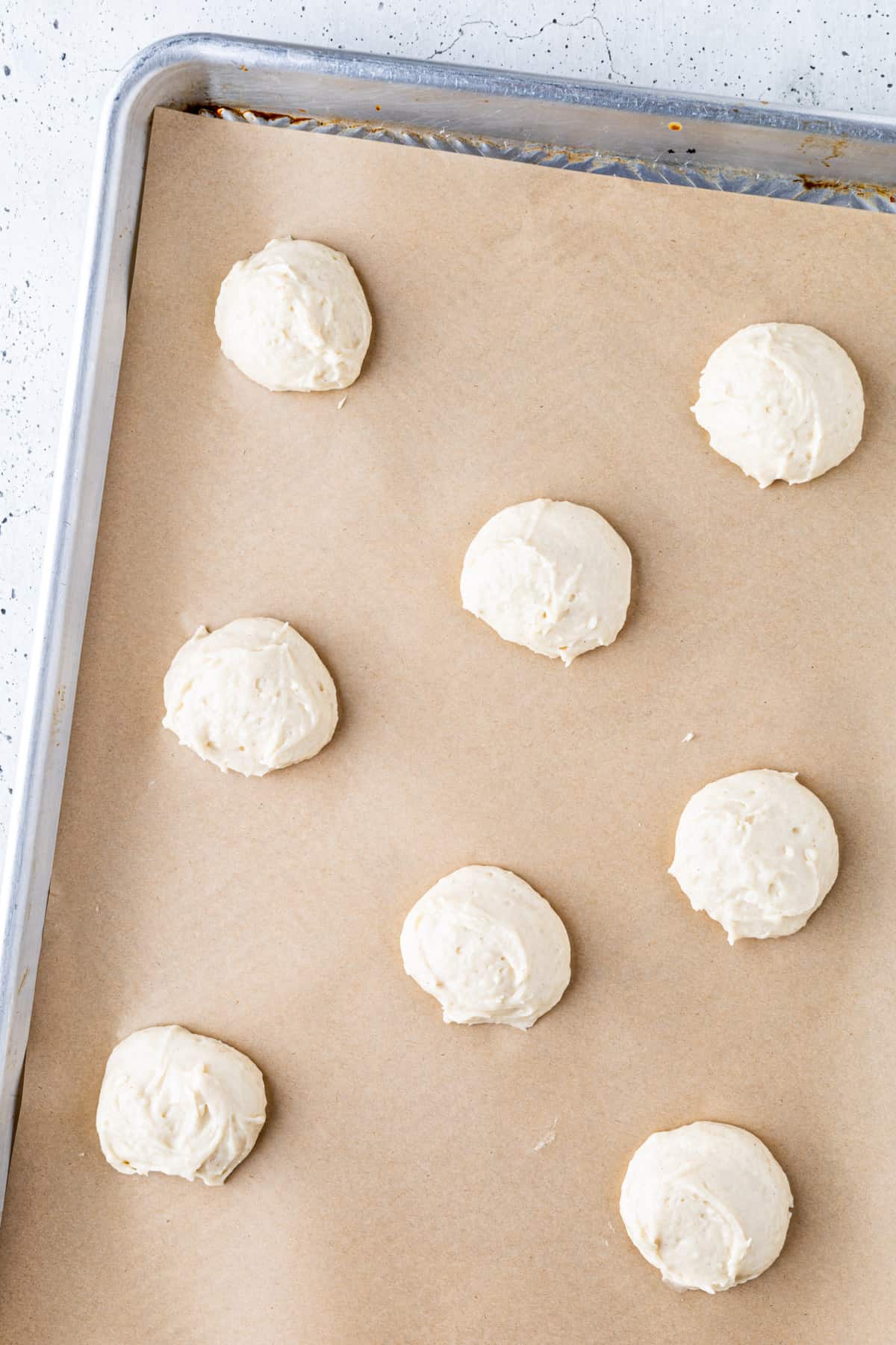 Cookie dough scooped onto a parchment-lined baking sheet.
