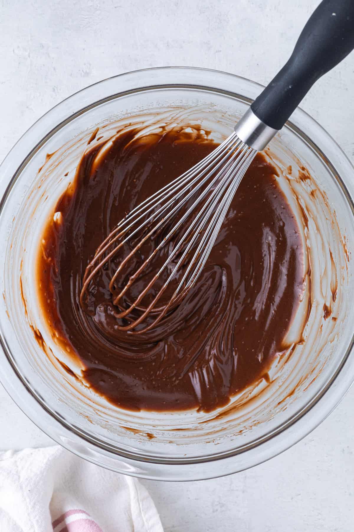 Chocolate-coffee mixture in a large bowl with a large whisk.