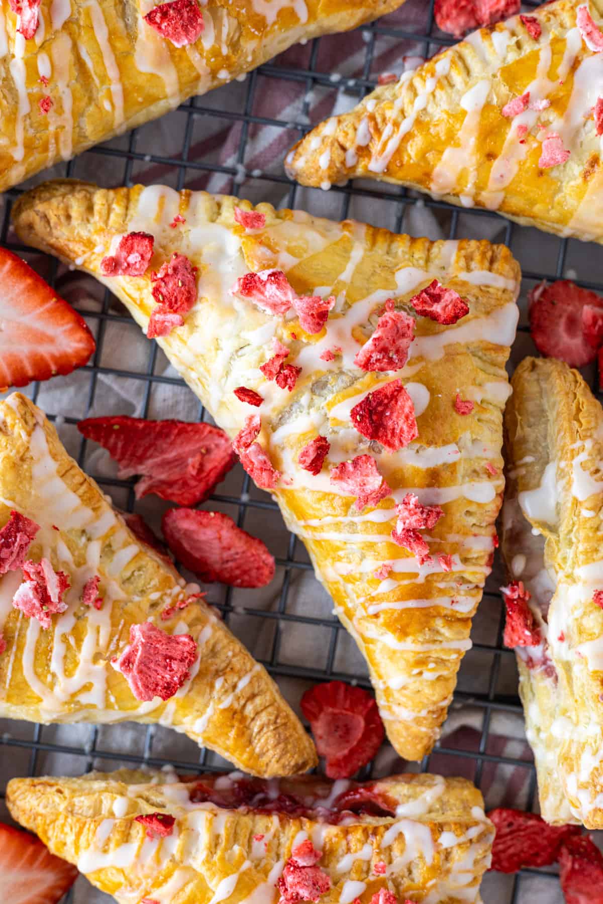 Strawberry turnovers on a wire rack.